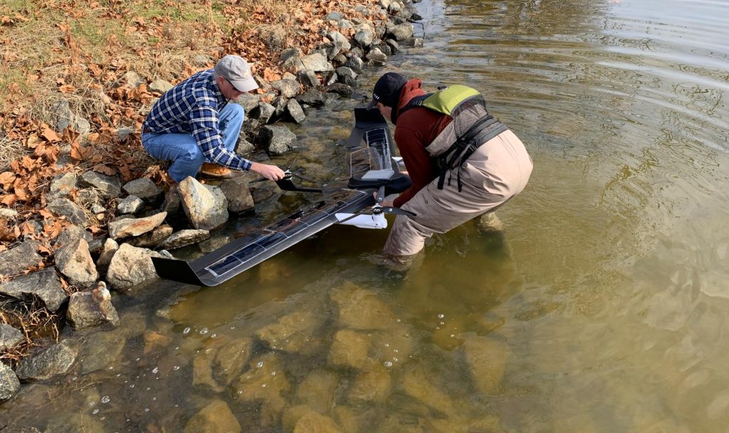 Científicos preparando el drone Hopper en la orilla del lago